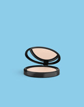 Ivory compact face powder in open black case with visible powder pan