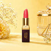 Lipstick with gold cap, maroon label, and coral-pink bullet