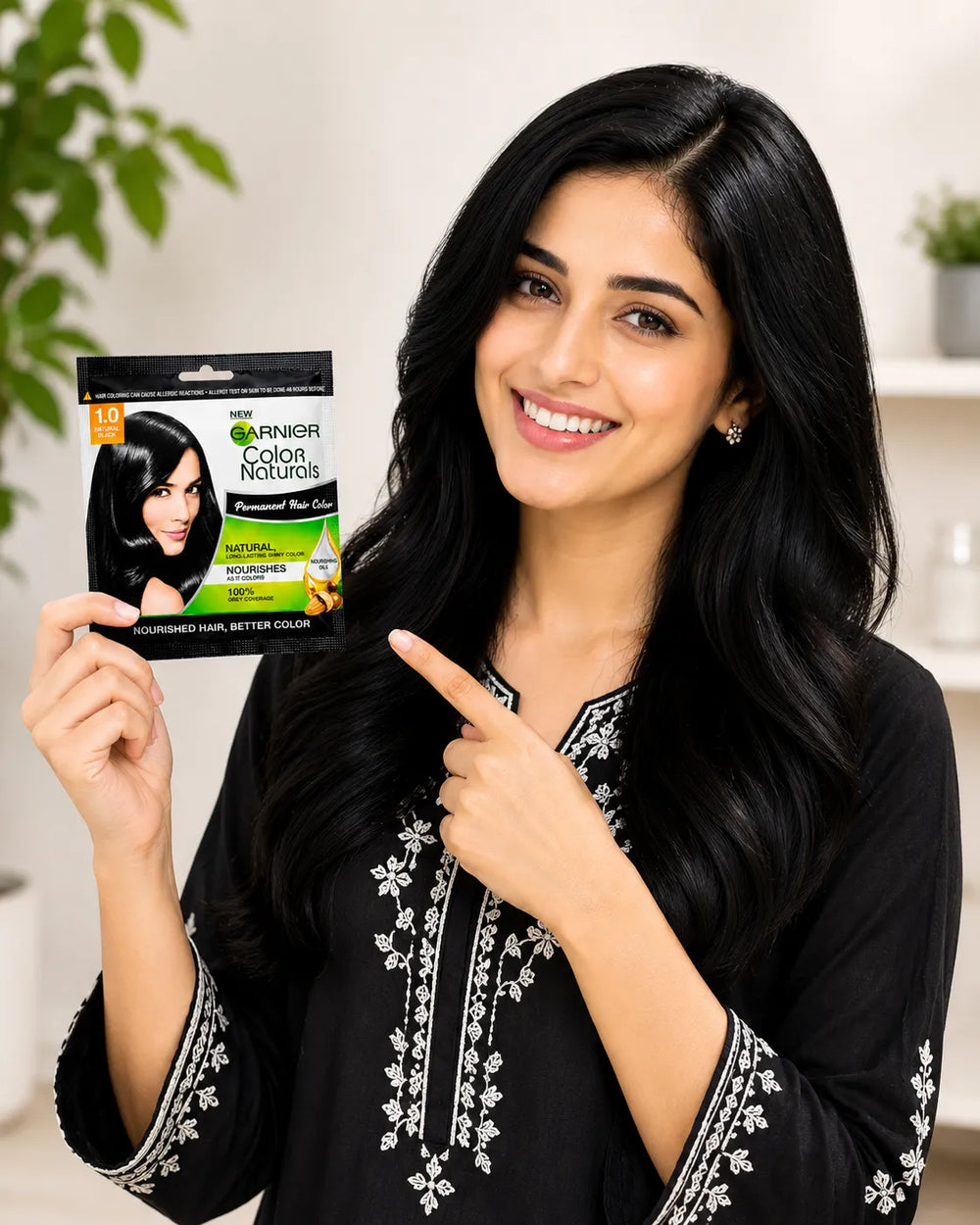 Woman holding hair color sachet box; dark glossy hair and 1.0 natural black label visible.