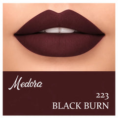 Close-up of dark berry lips with lipstick swatch