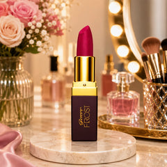 Genny Frost lipstick with magenta bullet, gold cap on marble base