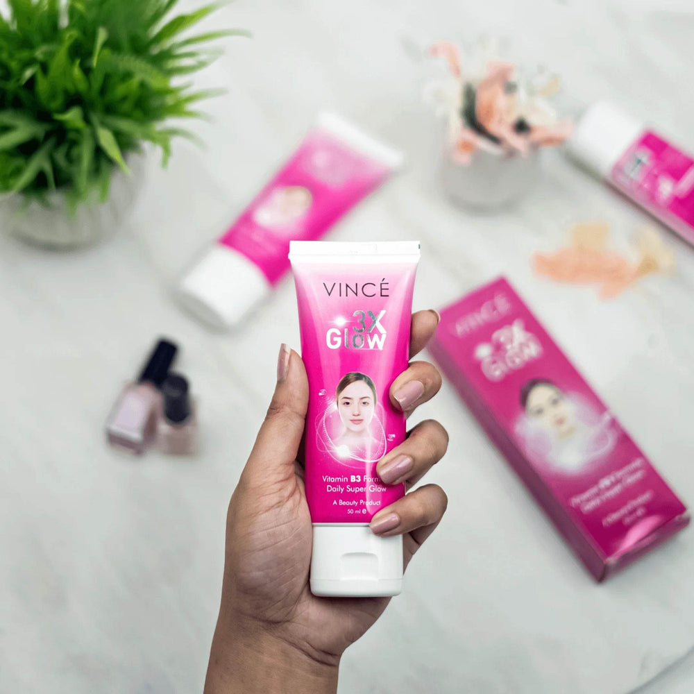 Hand holding Vince 3x Glow Cream tube, pink/purple front label, white cap